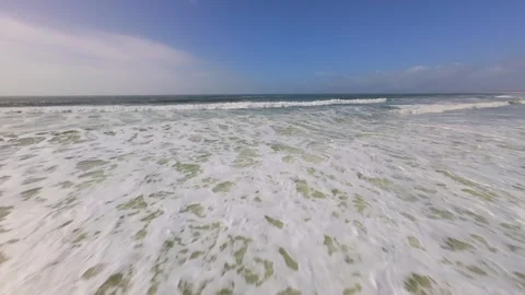 Beach scene with foamy waves and soft sand under bright sun Stock Footage 345061106