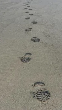 Beach scene of a path made with foot prints in sand Stock Photos