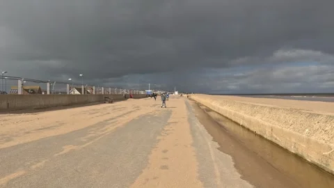 Beach scene on a summers day. Boy riding his hover-board.on the seafront be.. Stockbeeldmateriaal 240285754