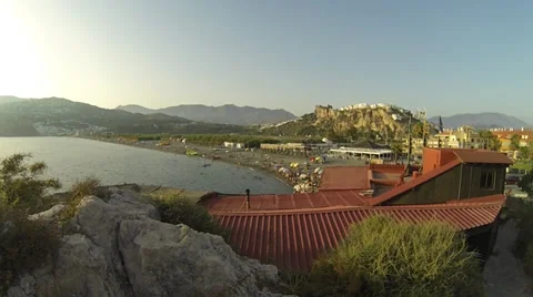 Beach scene as sun sets slow handheld pan left Stock Footage 30572479
