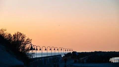 A beach scene with a sunset in the background Stock Photos