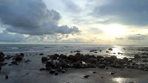 Beach scene with tide pool, clouds, sunset, and waves Stock Footage 74290218