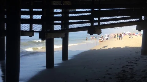 Beach scene from under a pier Stock Footage 71112217