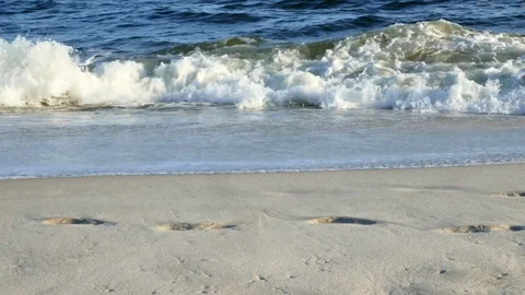 Beach scene with waves and foot prints Stock Footage 87917551