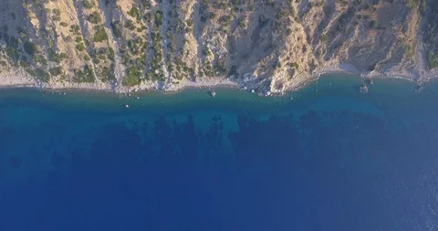 Beach, sea under cliffs and big mountain reveal Stock Footage 93399228