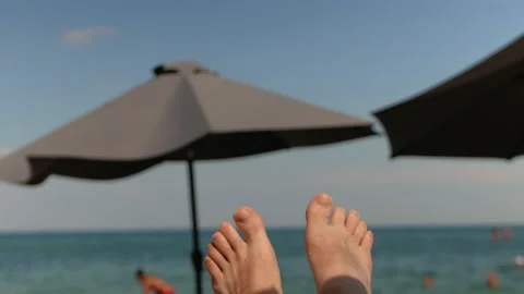 Beach shore, blue sky. Protective beach umbrella from sun. Strong wind Stock Footage 159795007