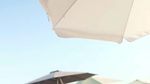Beach shore, blue sky. Protective beach umbrella from sun. Strong wind Stock Footage 159795074
