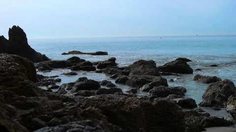Beach side rocks with calming waves Stock Footage 54565922