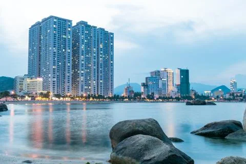 Beach with skyscraper in dusk with reflections in ocean Stock Photos