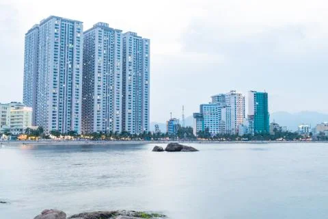 Beach with skyscraper in dusk with reflections in water Stock Photos