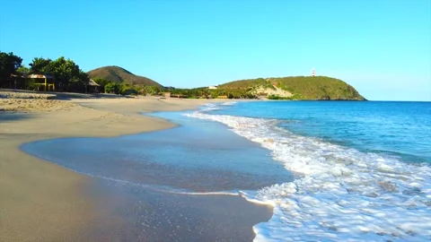 A beach with a small hill in the background Видео 294041987