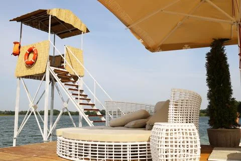 Beach sofa and rescue post on the shore of the lake Stock Photos