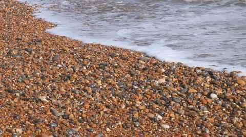 Beach with stones as small waves break over it Stock Footage 942058