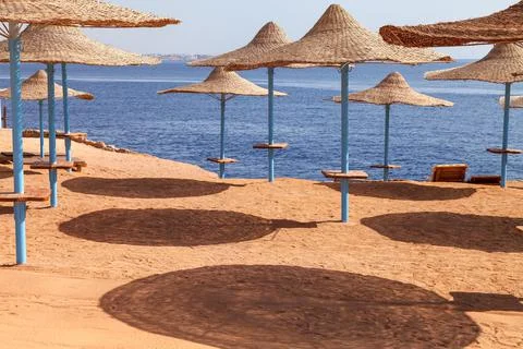Beach straw umbrellas on the background of the blue sea. Beach Vacation 库存照片