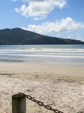 Beach in sunny day with hill in the background. Stock Photos