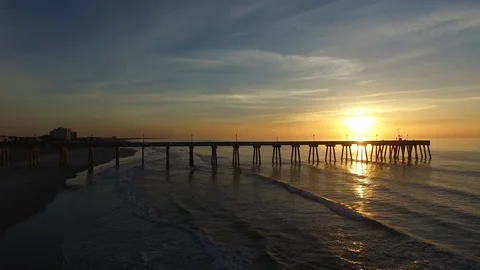 Beach Sunrise over ocean Pier, Rising shot over water. Stock Footage