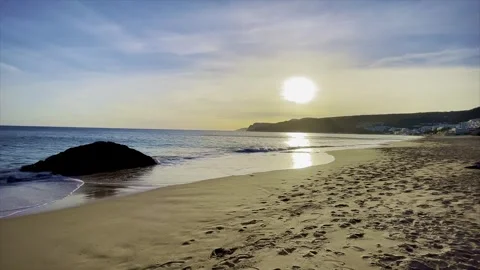 Beach with sunset and cliffs in the background Stock Footage 243748334