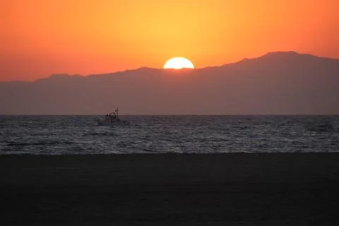Beach Sunset behind a Mountain Stock Photos