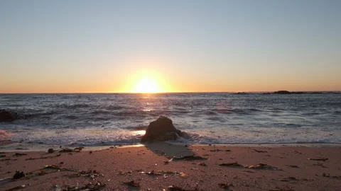 Beach at sunset with boulder on shore. Slow motion forward movement Stock Footage 161246228