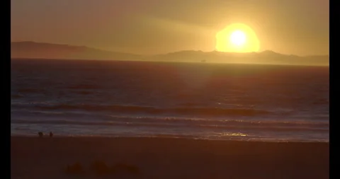Beach Sunset with a couple sitting in the sand Stock Footage 292958018