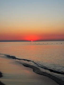 Beach Sunset with Gentle Wave Trail Stock Photos