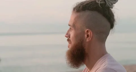 Beach at sunset man in deep thoughtfulness side view close-up Thoughtfulness Stock Footage 268600112