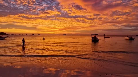 Beach Sunset with Orange Clouds and Playful Ocean Frolic 1 Stock Footage 240878236