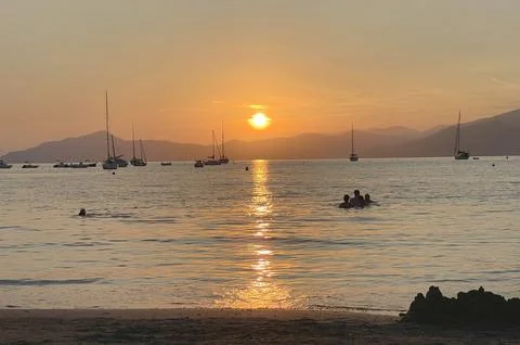 Beach at sunset time in summer on beach. Nature and mountains. Vacation in Stock Photos