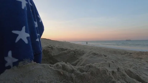 Beach Sunset with US Flag Towel in Foreground Stock Footage 114890265