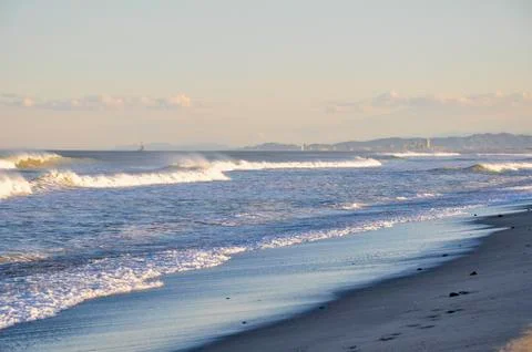 Beach at sunset with waves Stock Photos