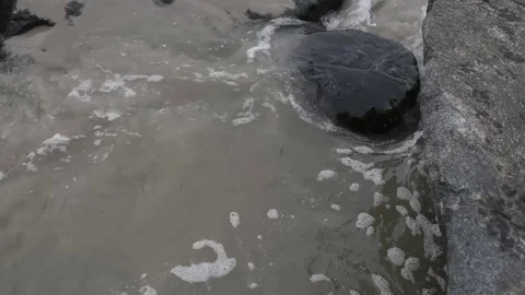 Beach surf moving over and around jetty pilings Stock Footage 75763885