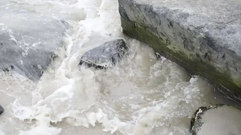 Beach surf moving over and around jetty pilings Stock Footage 75763933