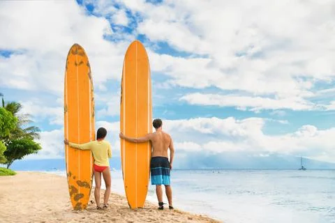 Beach surfers watching waves. Surfing lifestyle. Two people couple standing with Stock Photos