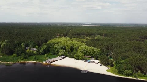 The beach is surrounded by a forest, on the shore of which there is a restaurant Stock Footage 321944326