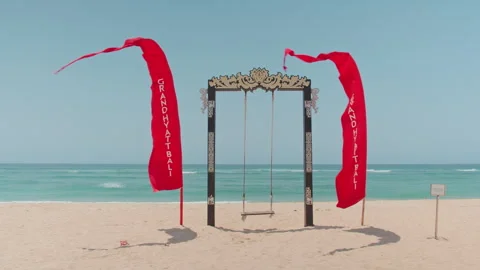 Beach swing and red banners , Nusa Dua, Bali 库存影片 336515272
