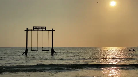 Beach swing and watching ocean waves. Carefree summer moment at ocean beach. Stock Footage 197015975