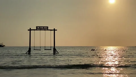 Beach swing and watching ocean waves. 動画素材 197057710