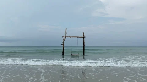 Beach swing and watching ocean waves. 動画素材 197058885