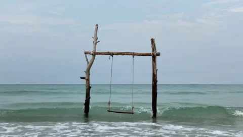 Beach swing and watching ocean waves. Carefree summer moment at ocean beach. 動画素材 197061858