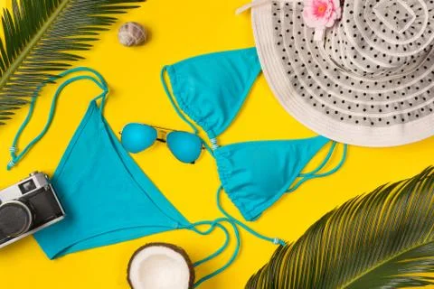 Beach theme on the yellow background. Camera, hat, palm leaves, swimsuit  on  Stock-Fotos