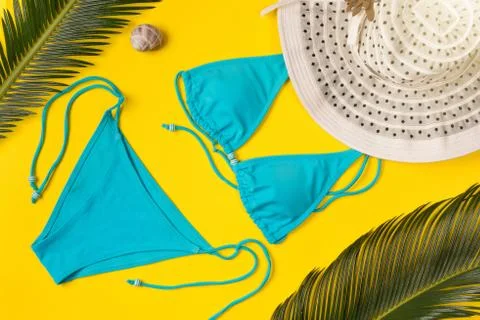 Beach theme on the yellow background. Hat, palm leaves, swimsuit  on the yell Stock Photos