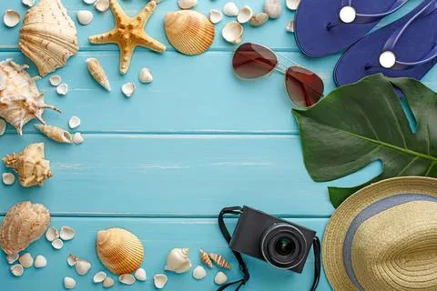 Beach-themed flat lay with shells starfish and camera Stock Photos