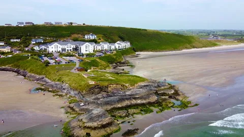 A beach with a thin strip of white sand, bordered by rocky cliffs Stock Footage 281443725