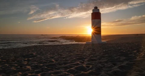 Beach Time lapse at sunset with lighthouse and vivid colorful sky Stock Footage 130986479