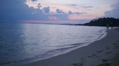 Beach timelapse with two people walking down the beach at sun set Stock Footage 60401260