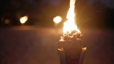 Beach Torch Burning in Sand Night Refocus to Sunbeds Tropical Island Cozy 4K Stock Footage 335863199