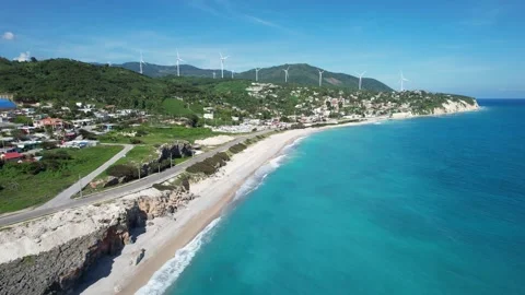 Beach town beneath wind turbines on a hillside, aerial view Stockbeeldmateriaal 278370179