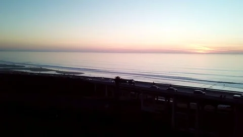 Beach Town Post Sunset Rush Hour traffic crossing a Bridge as drone ascends Stock Footage 84758361
