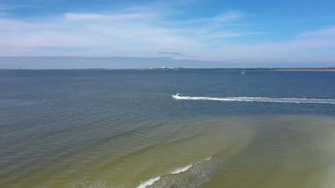 Beach tracking boat leaving into ocean Stock Footage 156403374