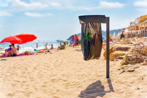 Beach Trash Bin Surrounded by Excited Sun Bathers in Tarragona, Spain Stockfoto's